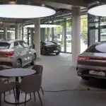 Samochody BYD i stolik dla klientów w jasnym salonie